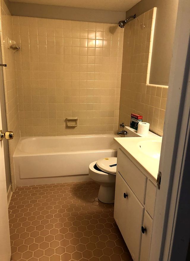 Bathroom in Unit 102 with a white tub, tiled surround, and clean grout