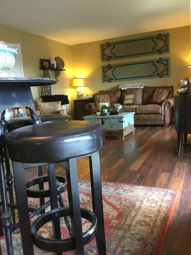 Decorated living room in Unit 207 with sofa, rug, and wood-look flooring — furniture not included