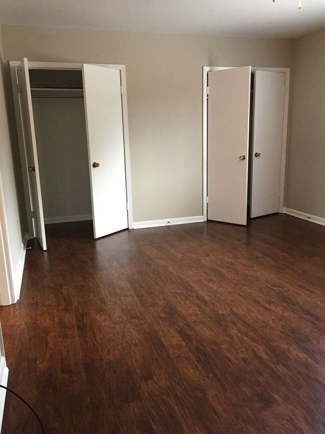 Upgraded unit room with Agreeable Gray walls and dark wood-look flooring